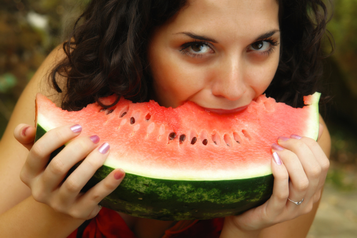 young woman eating a piece of watermelon
