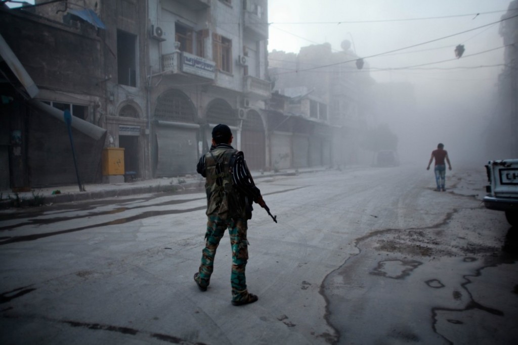 A rebel fighter stands on a street covered with dust following a reported air strike by Syrian government forces in the old city of Aleppo on July 21, 2014. Aleppo was Syria's most populous city before the conflict, but it is now a major battle zone split into areas controlled by the rebels concentrated in the east and those held by the government mainly in the west.    AFP PHOTO / AHMED DEEB        (Photo credit should read AHMED DEEB/AFP/Getty Images)