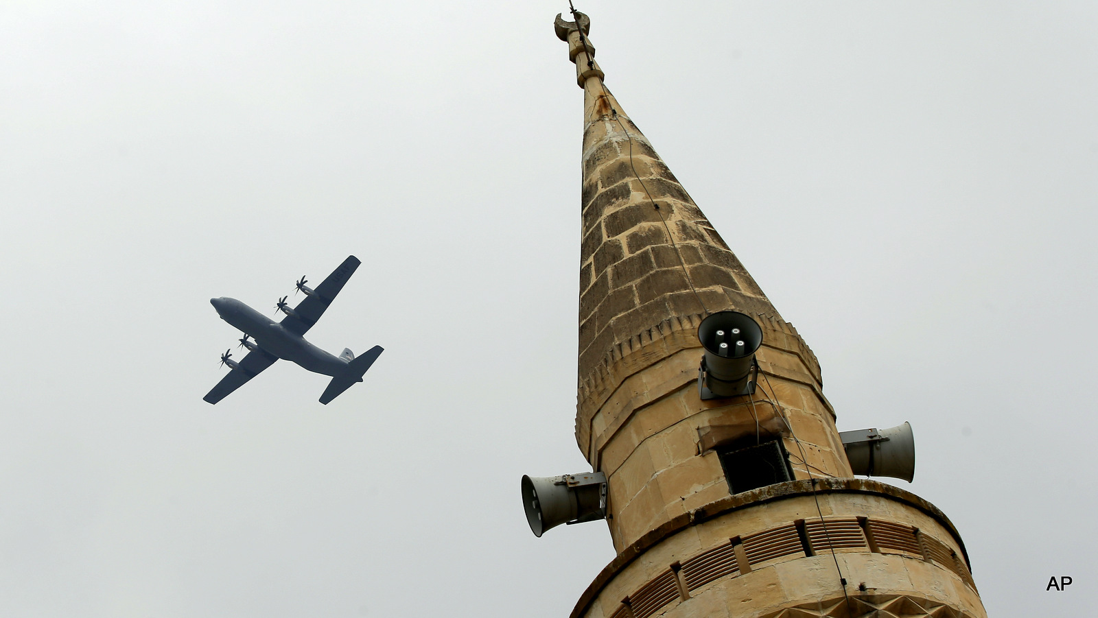 With a mosque's minaret in the foreground, a United States Air Force cargo plane takes off from the Incirlik Air Base, in the outskirts of the city of Adana, southern Turkey, Thursday, July 30, 2015. Turkish Foreign Ministry spokesman Tanju Bilgic said Wednesday, that an agreement allowing the U.S.-led coalition against the IS to launch airstrikes from Incirlik and other Turkish bases has been approved by Cabinet. (AP Photo/Emrah Gurel)